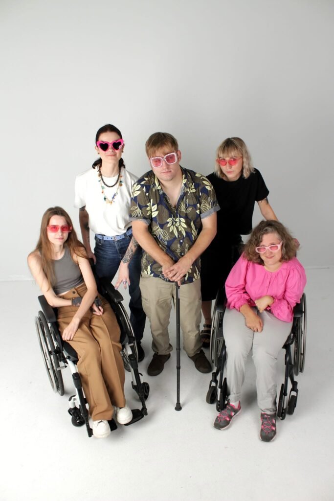 Penki žmonės su spalvotais akiniais nuo saulės fotostudijoje